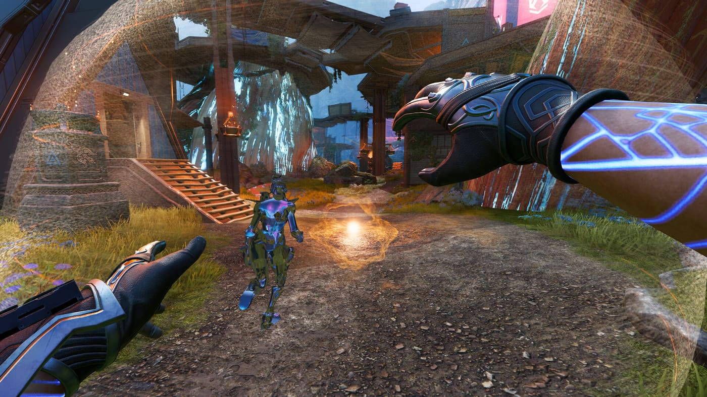 First-person view in Apex Legends of a Legend holding a weapon with glowing blue panelling, one arm marked with bright blue circuitry, advancing on an enemy Legend standing in the open in an overgrown ruined settlement. Official Apex Legends™ screenshot supplied by Electronic Arts.